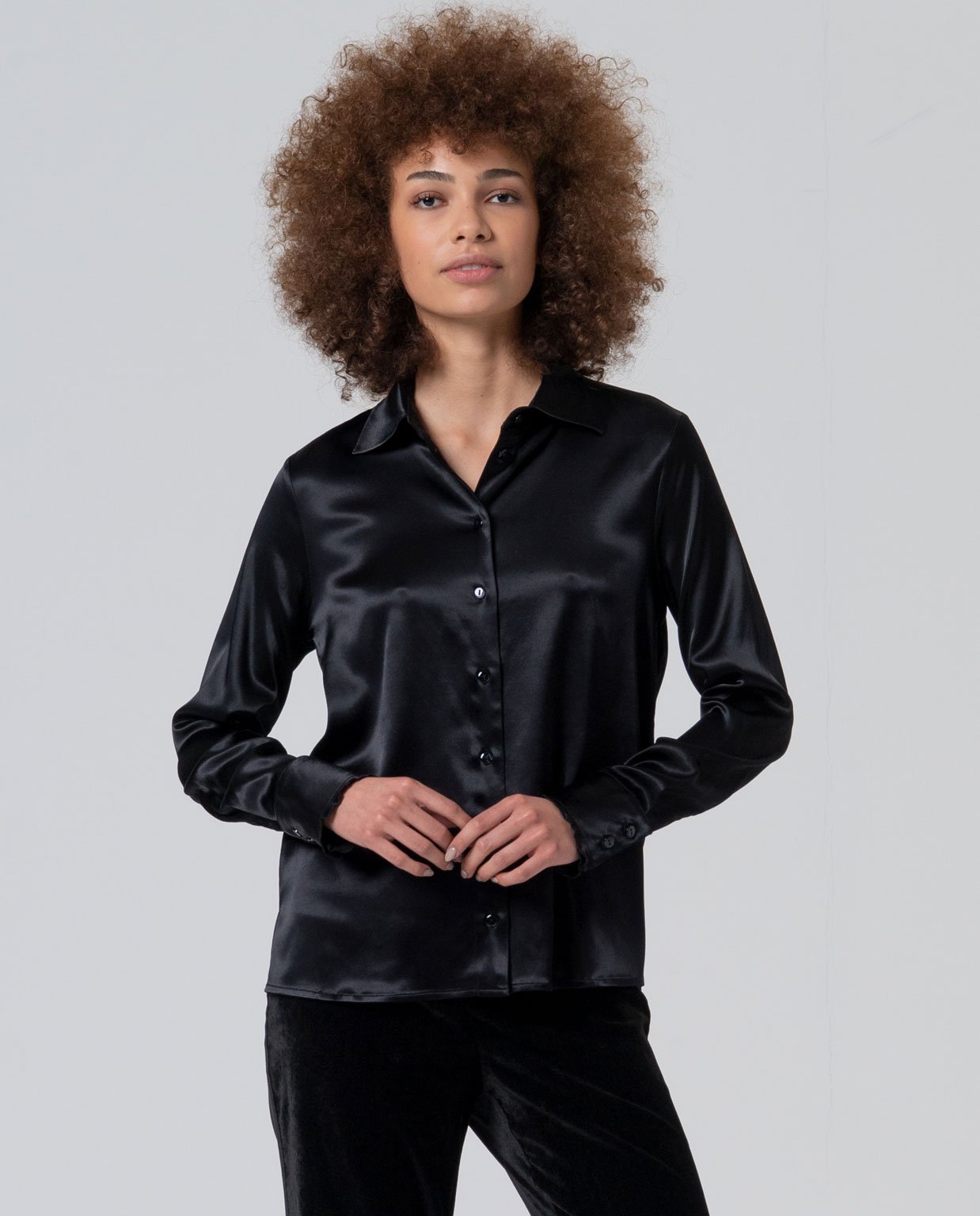 Camisa satinada negro detalle cuello avolantado.